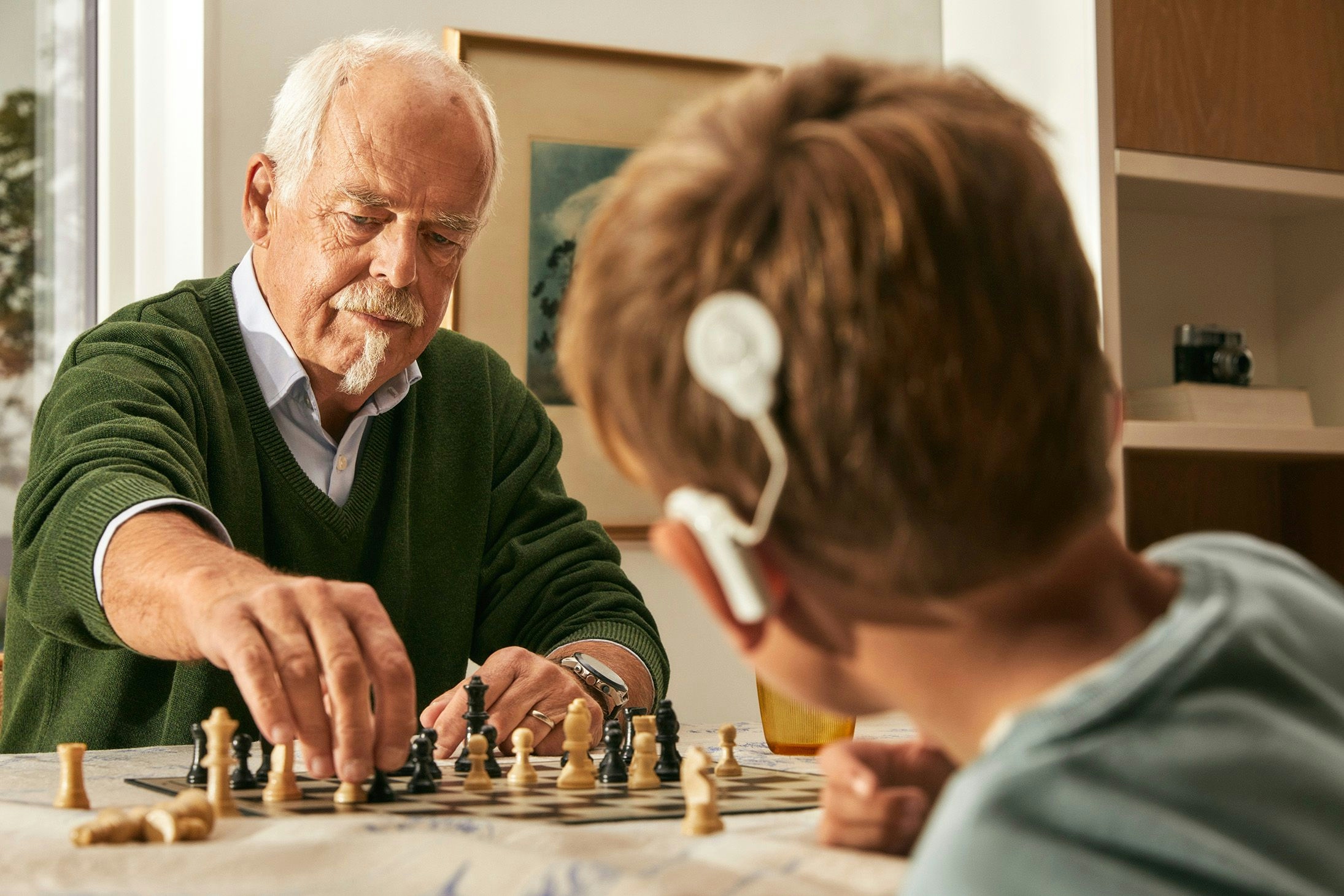 Bestefar og barnebarn med CI spiller sjakk